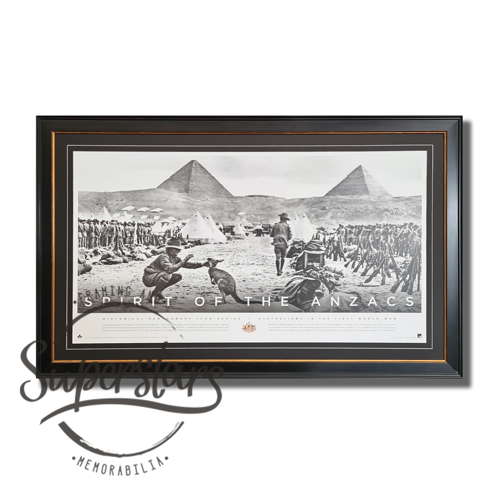 This framed poster is a piece of ANZAC memorabila. It features a large, landscape black and white photo of the Aussie soldiers lined up, the pyramids in the background. In the foreground is a soldier shaking hands with a kangaroo.