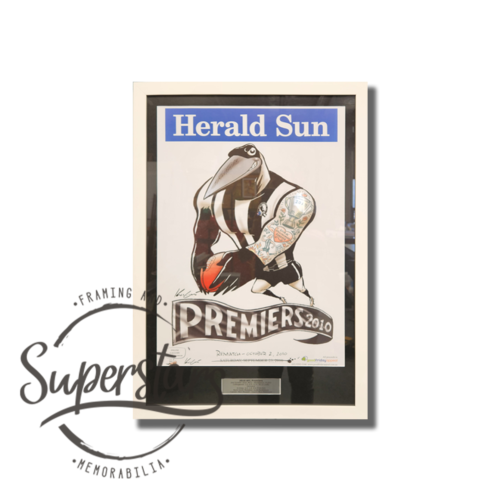 Collingwood Premiership Memorabilia. 1958 VFL Premiers. A cartoon magpie is the main feature, with the word Premiers across the bottom. This has been framed with a black border, white timber frame and silver plaque.