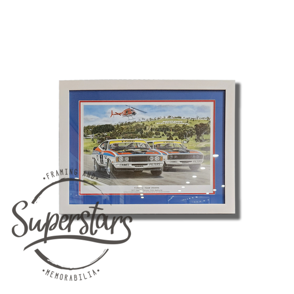 vintage Ford memorabilia at it's best. a colourful sketch of Ford crossing the finish line in both first and second place. It is frames with blue and red borders and a white frame.