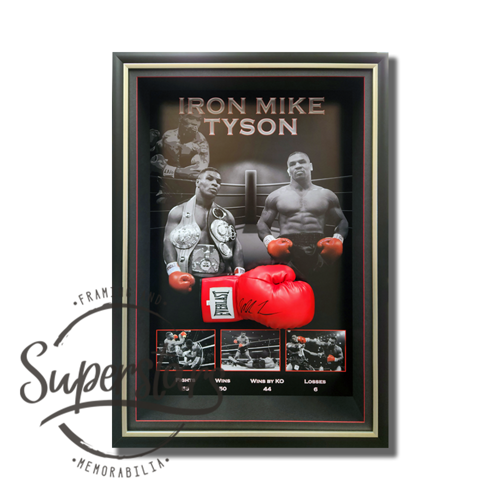 The main feature is a red boxing glove that has been signed by Mike Tyson in black ink. Behind the glove is a a collection of black and white images that show him in action. The bottom summarises his key career statistics. The frame is portrait in orientation and is surrounded by black timber frame with gold trim.